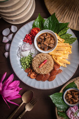Beautifully arranged Thai shrimp paste fried rice, known as Khao Kluk Kapi, served with traditional side ingredients such as sweet pork, sliced omelet, red chili, shallots, dried shrimp, green beans, 