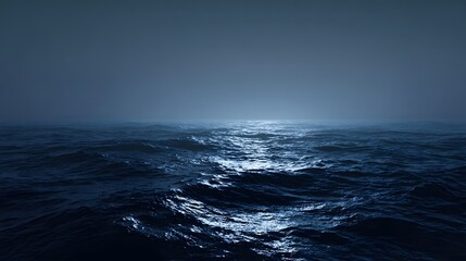 Obraz premium Dark, choppy ocean water reflects moonlight under a foggy sky.