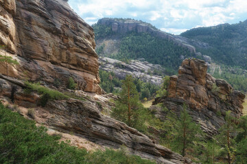 The rocky landscape of the Kent Mountains in Central Kazakhstan is the Karkaraly Nature Park with its bizarre rock formations, trees, and blue skies.