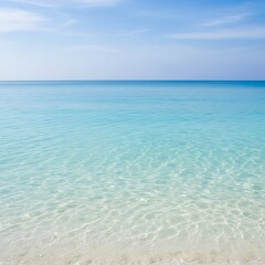 Crystal Clear Turquoise Ocean Water Meets Sandy Beach Under a Blue Sky.