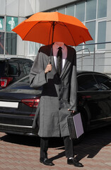 A headless man standing in a raincoat