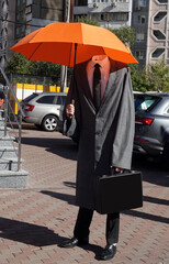 A headless man standing in a raincoat