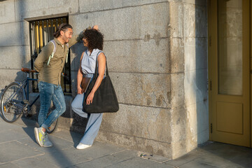 Interracial couple talking, smiling, and flirting on street