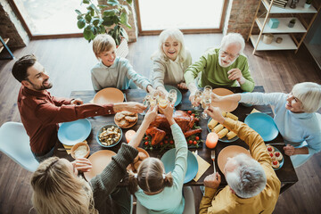A lively family gathering around a long table sharing a Thanksgiving feast to celebrate togetherness love and gratitude with friends and relatives in a cozy home setting