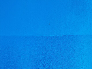 Grunge blue background with cracked paint. Old blue paint on the wall texture. Abstract background for design with copy space for text or image.