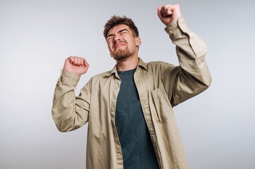 Man enjoying music while dancing against a simple background during a casual indoor setting