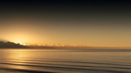 Golden sunrise rays pierce clouds over calm ocean waters.