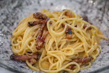 Fresh Italian spaghetti carbonara with pancetta at a restaurant in Nice, France