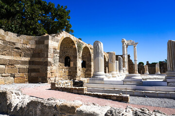 Exploring Ancient Architecture: A Journey Through Historical Ruins with Towering Columns and Arched Structures Under a Clear Blue Sky