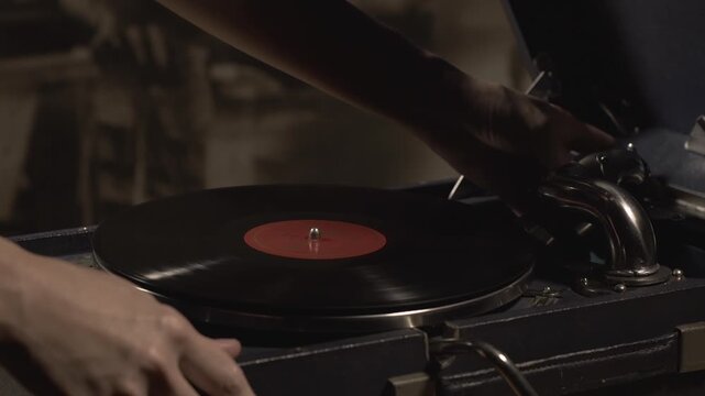 Close-up of a vinyl record spinning inside of the vintage gramophone. Using a spinning vinyl record to listen to beautiful music. Vinyl record of the old music group is spinning in the phonograph.