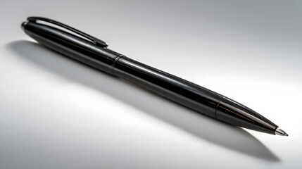 Sleek black writing instrument rests on a reflective surface.