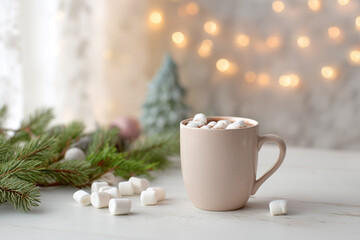 A cup of cocoa with marshmallows on a light background with a Christmas tree and garlands. Light Christmas background. 
