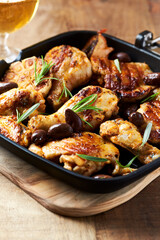 Grilled chicken pieces with kalamata olives and fresh rosemary. Close up.	