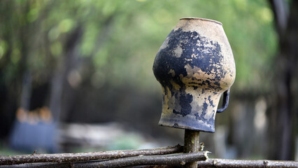 Beautiful handcrafted Ukrainian ceramic pots and jugs are decorating a traditional wicker fence in the countryside, showcasing the beauty of Ukrainian rural life. close-up