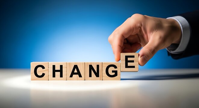 Businessmans hand places the letter e on wooden blocks spelling change, symbolizing transformation and progress