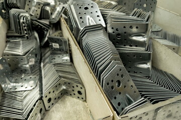 Metal brackets and connectors neatly arranged in storage boxes at a construction supply warehouse...