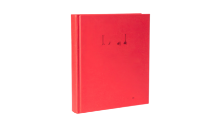 A vibrant red book stands against a black backdrop, with minimal text on the front