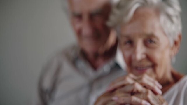 Senior couple smile holding hands. Elderly portrait conveys intimacy and togetherness. Warm love and relationship visible in gentle expressions. Calm atmosphere suitable for family wellbeing themes.