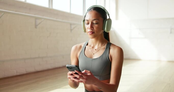 Headphones, smartphone and woman in studio, fitness and texting with social media. Sound, exercise and person in health club, cellphone and music break with album playlist, app and message to contact
