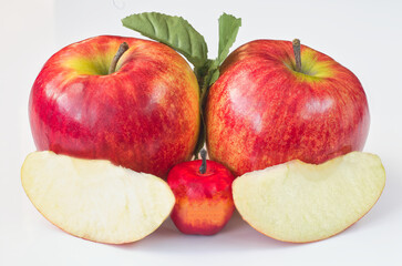 red large apples and their cut-out fragments on a white background