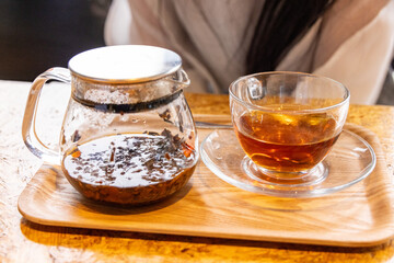 茶葉が入ったガラス製ティーポットとカップに注がれた紅茶