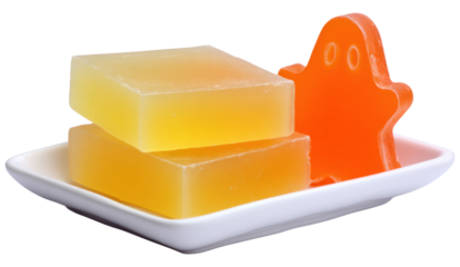 Colorful soap in a playful ghost shape alongside two rectangular bars, displayed on a white plate.
