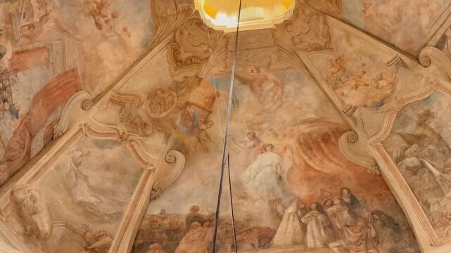 Exterior and interior views of the monumental St. Nicholas Church in Prague. Baroque dome frescoes, massive chandeliers, and intricate gilded stucco contrast with the passing city tram.