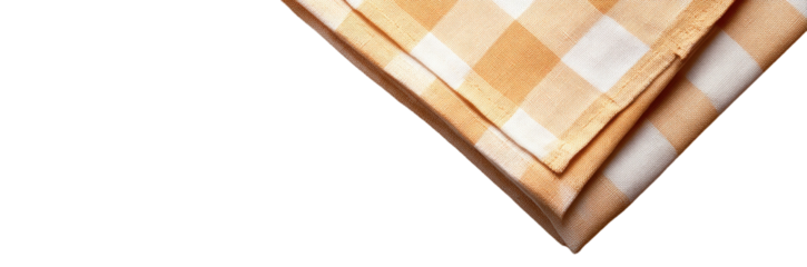 Close-up of a folded checkered textile with orange and white squares. Background is solid black