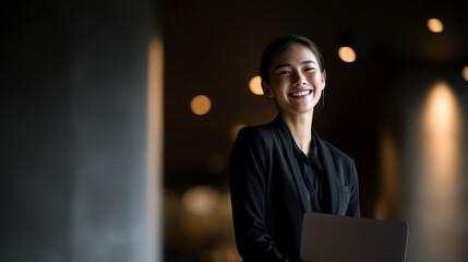 A Confident Young Smiling Asian Businesswoman Poses Against a Professional Background, Embodying Success and Entrepreneurial Spirit in the New Workforce.