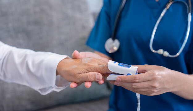 female hands in uniform with stethoscope is measuring pulse oximeter senior woman,healthcare worker or nurse physical examination old patient - Powered by Adobe