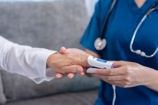 female hands in uniform with stethoscope is measuring pulse oximeter senior woman,healthcare worker or nurse physical examination old patient