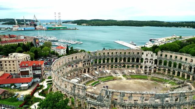 Flying above historic city of Pula , historic Roman amphitheatre of Pula aerial view, tourism in Croatia