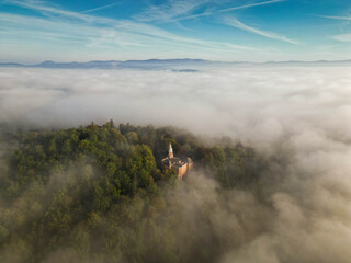 Morning Mist over Countryside Road and Fields in Mountain Valley. Peaceful autumn sunrise scene with soft light and long shadows, symbolizing calmness and nature&rsquo;s beauty.
