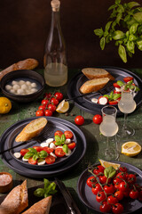 Italian dinner with caprese salad, mozzarella, tomatoes, basil and limoncello