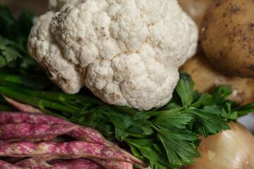 different vegetables raw, fresh from organic farmers market from soil to table: broccoli, cauliflower, onion, potatoes, carrots, celery root, celeriac, cranberry beans, barbunya beans