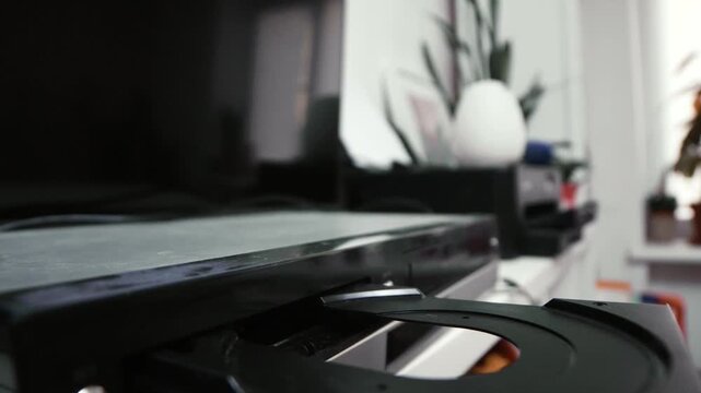 Woman puts a dvd disc into media player.