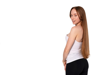 Fototapeta premium Young woman poses sideways with long hair in a casual outfit against a white background