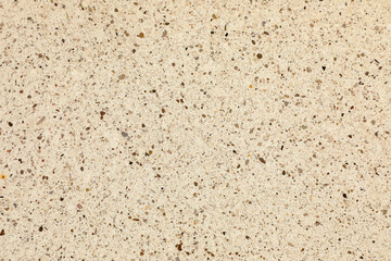 Natural stone chips embedded in smooth beige terrazzo create an elegant, organic pattern, perfect for interior design and modern visual compositions.