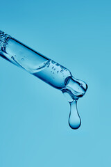 A serum pipette with lots of bubbles on a blue background.