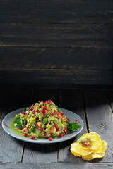 Salad decorated with pomegranate berries. Salads with pomegranate and chips.