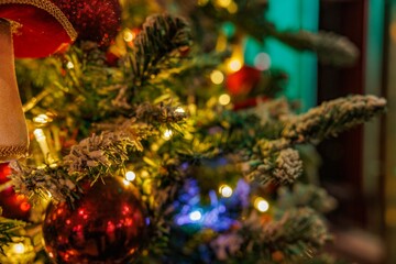 A beautiful Christmas tree trimmed with red ornaments and glowing lights creates a warm festive atmosphere.