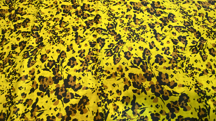 Bright yellow fabric with brown and black floral pattern, a vibrant textile