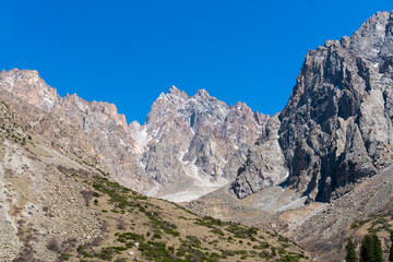 Ala-Archa Park, Steep rocky mountains rise sharply with jagged summits and sparse greenery. Trekking routes alpine climbing hiking expeditions and wilderness adventure in remote backcountry terrain