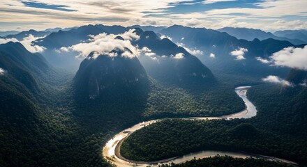 Lush rainforest with winding river and cloud covered mountains landscape aerial view