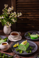 Lime matcha roll cake dessert with tea and jasmine flowers