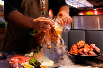 A chef pours a steaming mix from a unique vessel, crafting a delightful scene of vibrant dishes.
