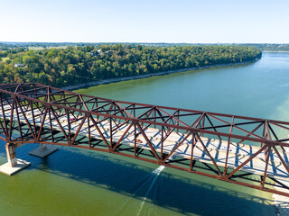 Aerial shot of rusty steel truss Bronston Bridge named The Houseboat Capital of the World Bridge spanning Cumberland River, with tree-lined banks and distant countryside