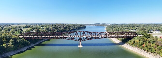 Aerial shot of rusty steel truss Bronston Bridge named The Houseboat Capital of the World Bridge spanning Cumberland River, with tree-lined banks and distant countryside