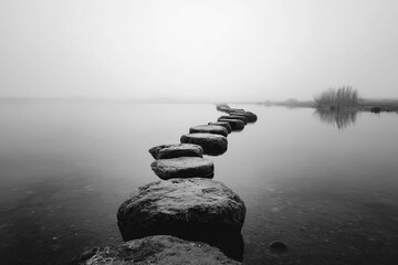 Fog-covered water with dark stone path disappearing into distance. Concept of journey, solitude, and meditative environment.