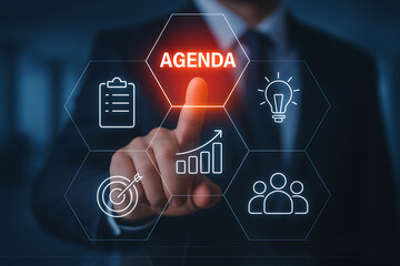 businessman hand pointing to glowing hexagon with agenda text surrounded by planning target idea chart and teamwork icons for business strategy